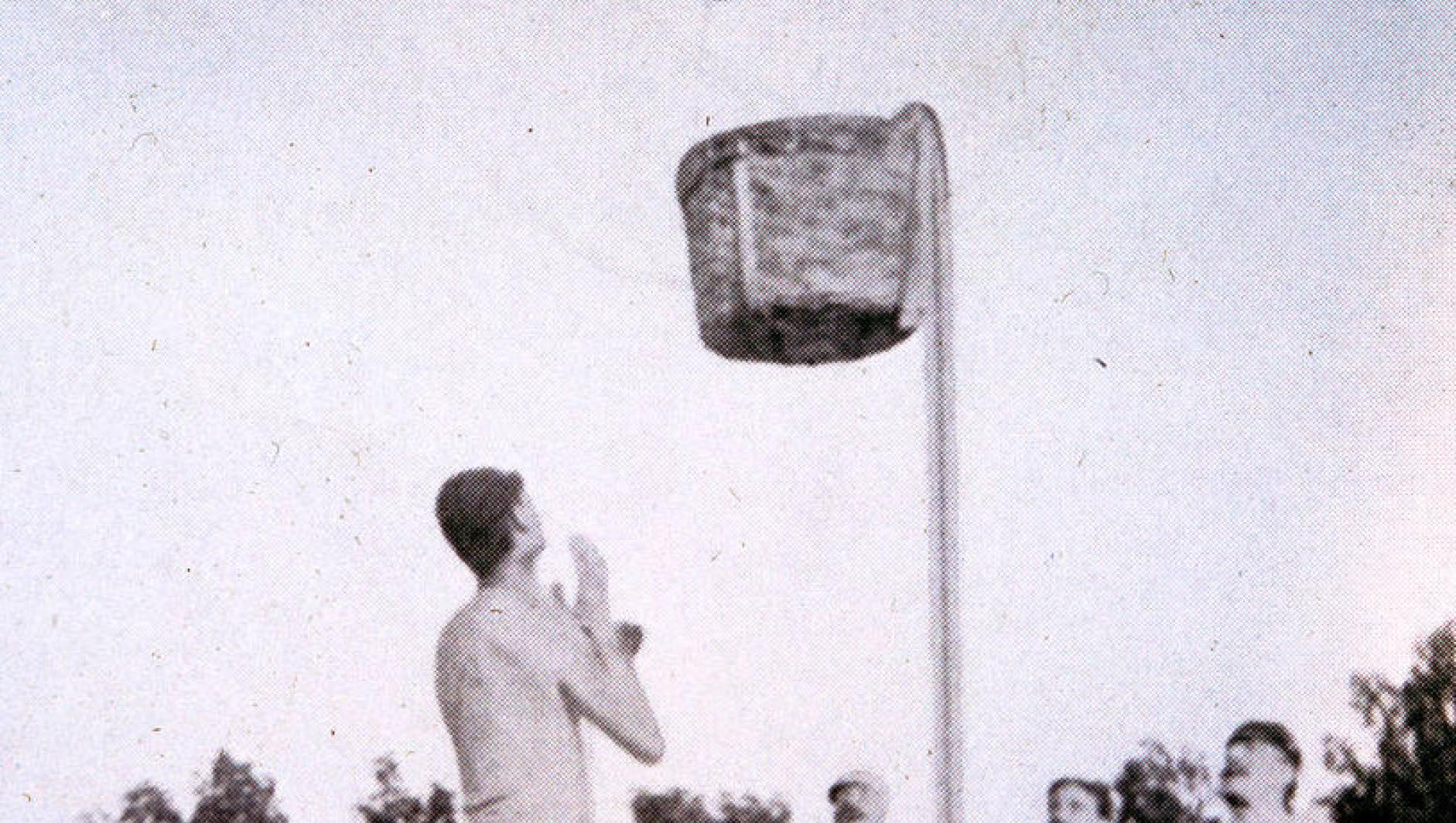 An early basketball game using a peach basket as a hoop.