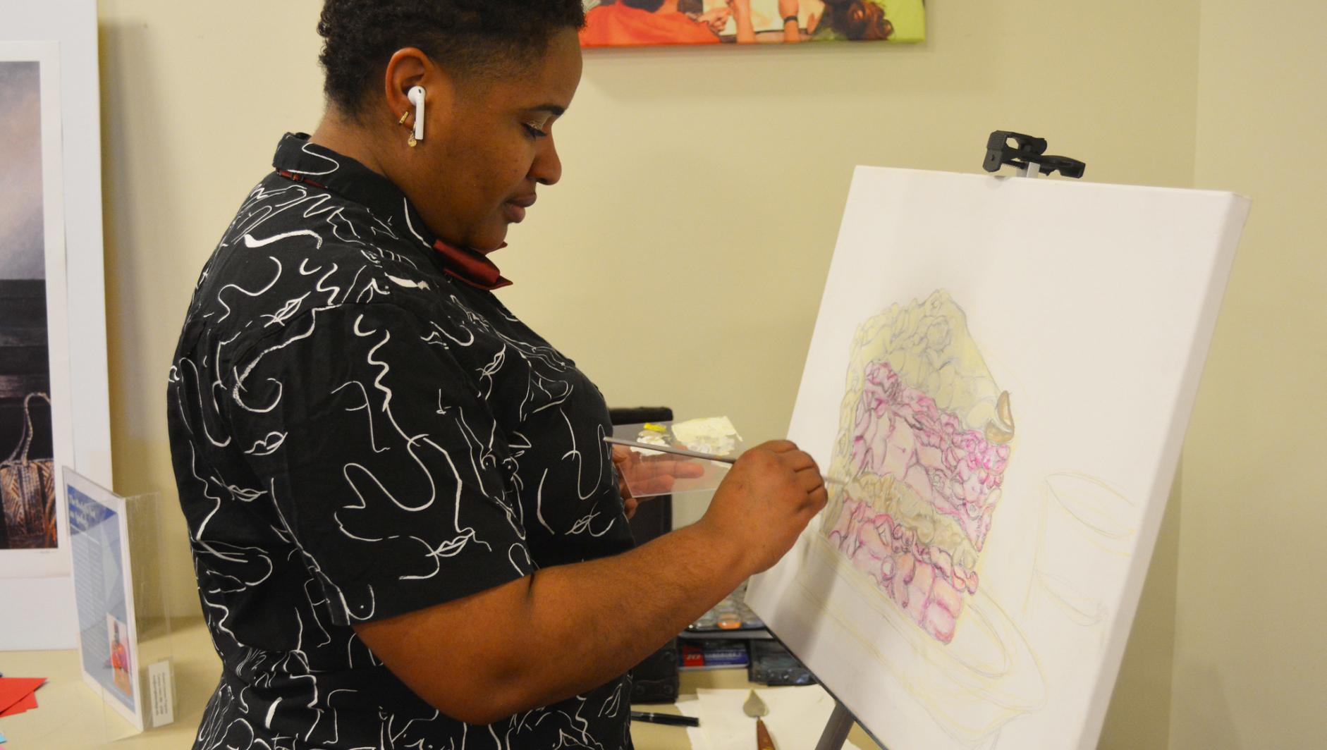 A student works on art at the fourth annual women's tea. 