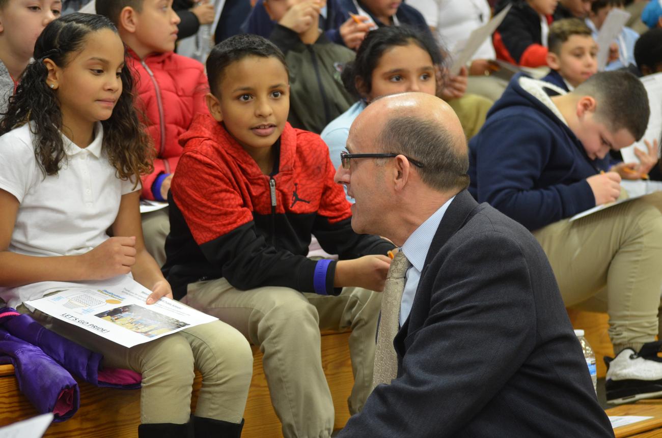 Springfield College Athletic Director Craig Poisson talks with youngsters from local Springfield elementary schools.