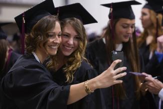 Two female students take a selfie at Springfield College commencement in 2016