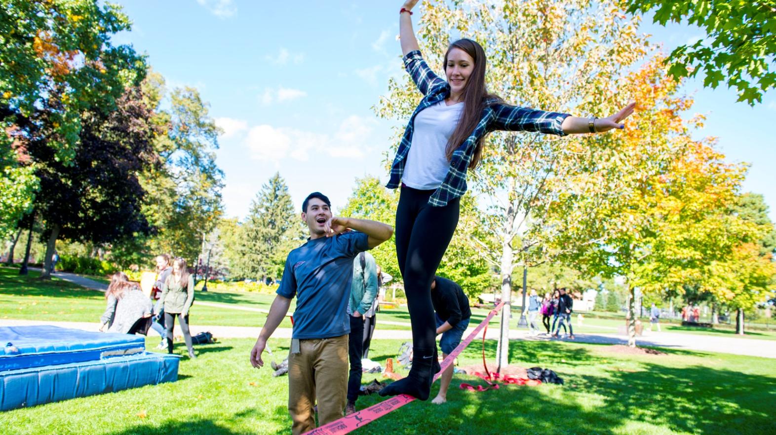 Springfield College students on the green walk on a tight rope