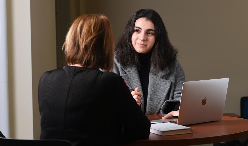 Female MBA student talking to a classmate with a laptop