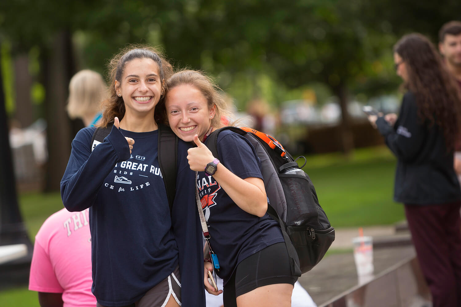 Two students give a thumbs up to the camera.