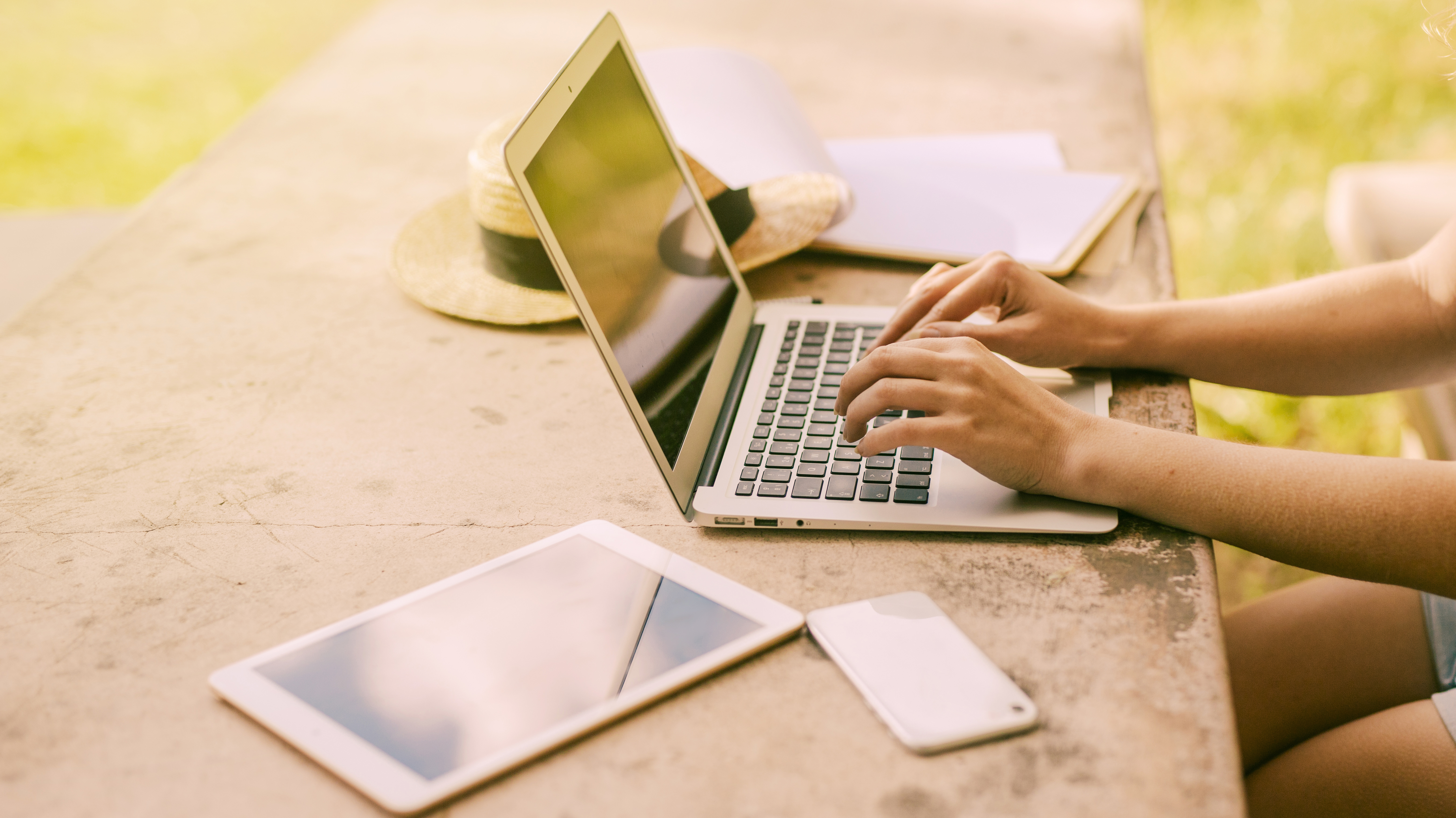 Girl works on laptop outside