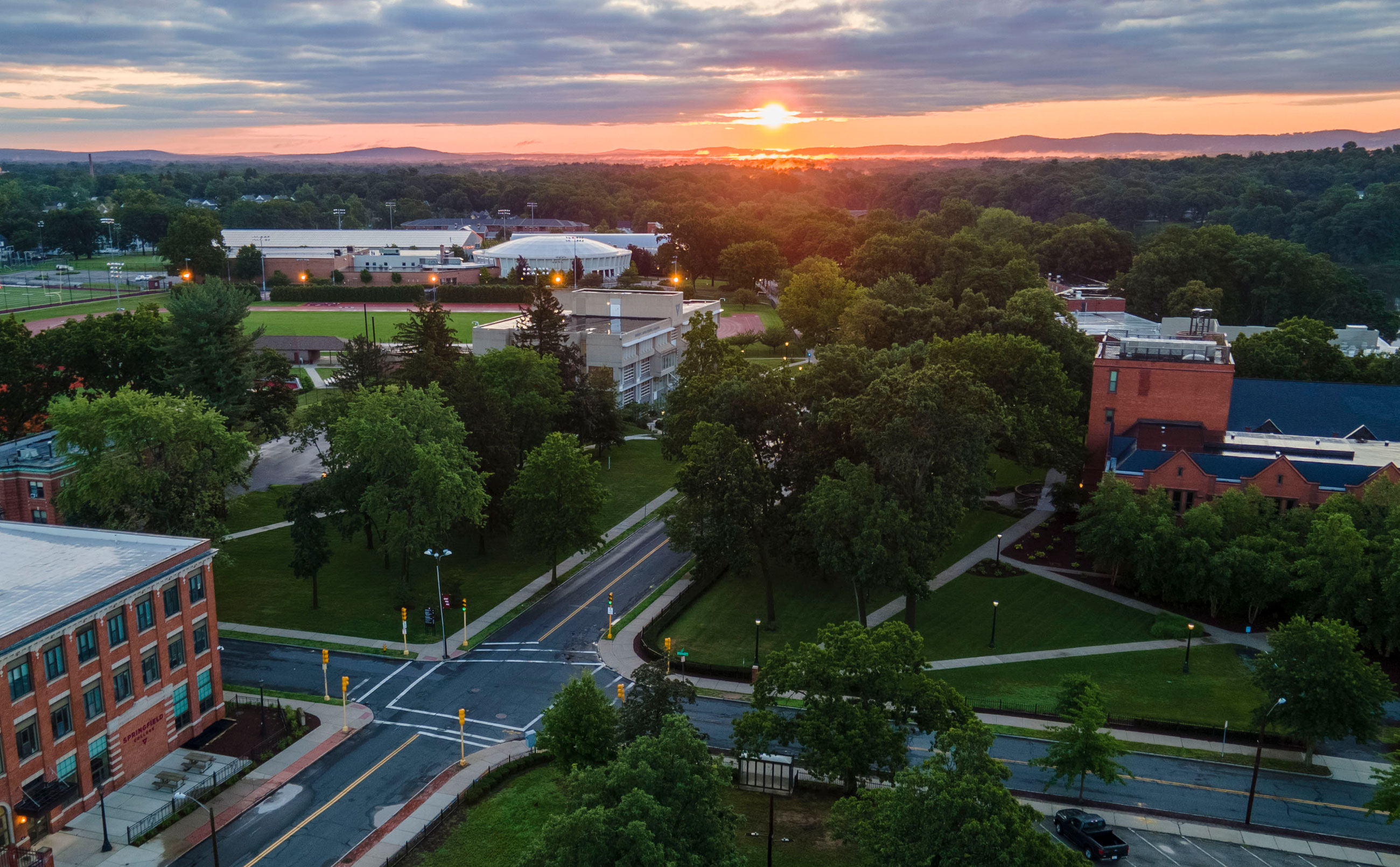 A drone image of a sunrise over campus