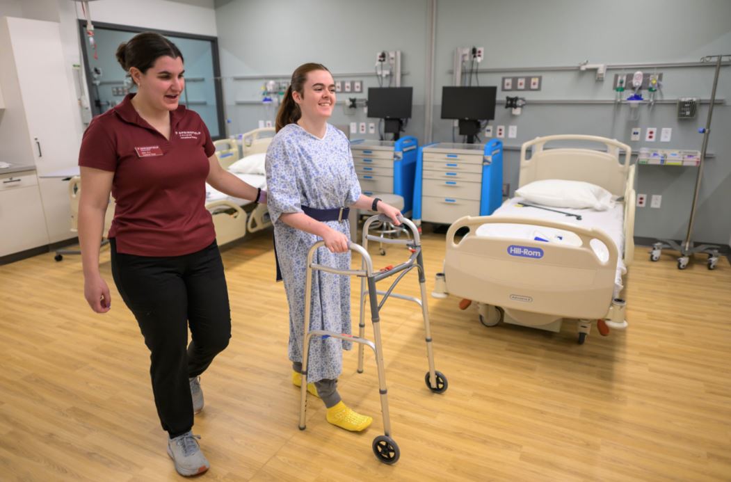 OT student walking patient in walker