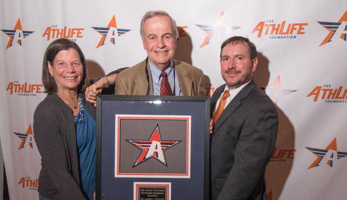 Phyllis Lerner, Al Petitpas, and Jeff McCann pose with Al as he receives the AthLife Foundation's Youth Inspire Award.