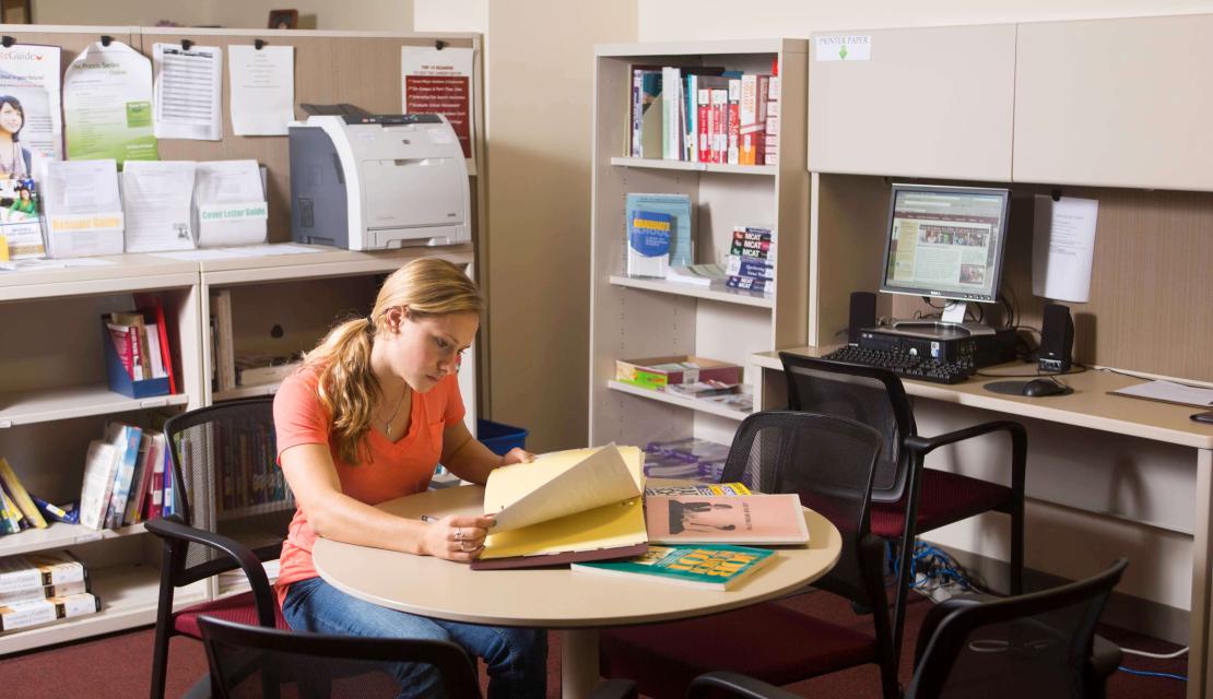 A girls sits at a table in the Career Center