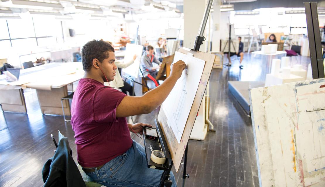 A student works in an art studio. 