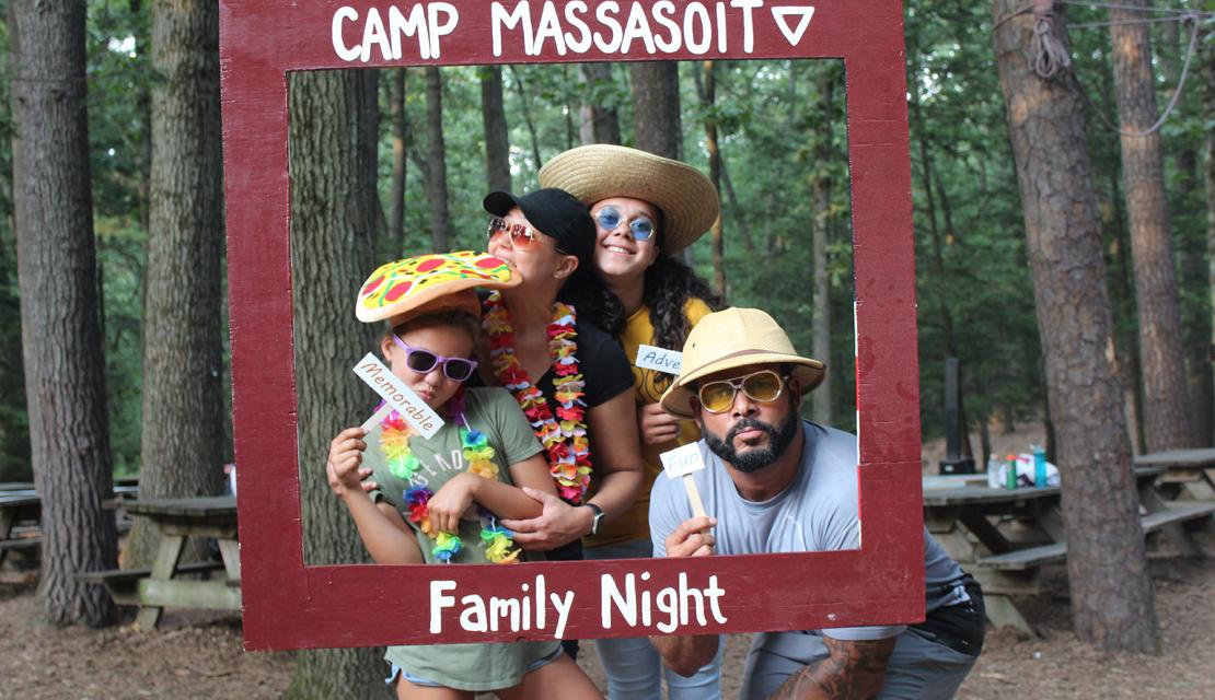 Family at Family night at Camp Massasoit pose in a picture frame