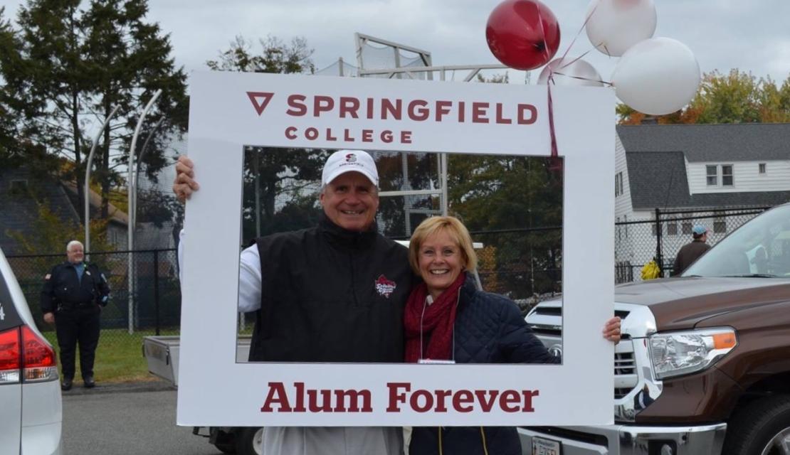 Buzzy and Barb Ernst stand in an Alumni Forever frame