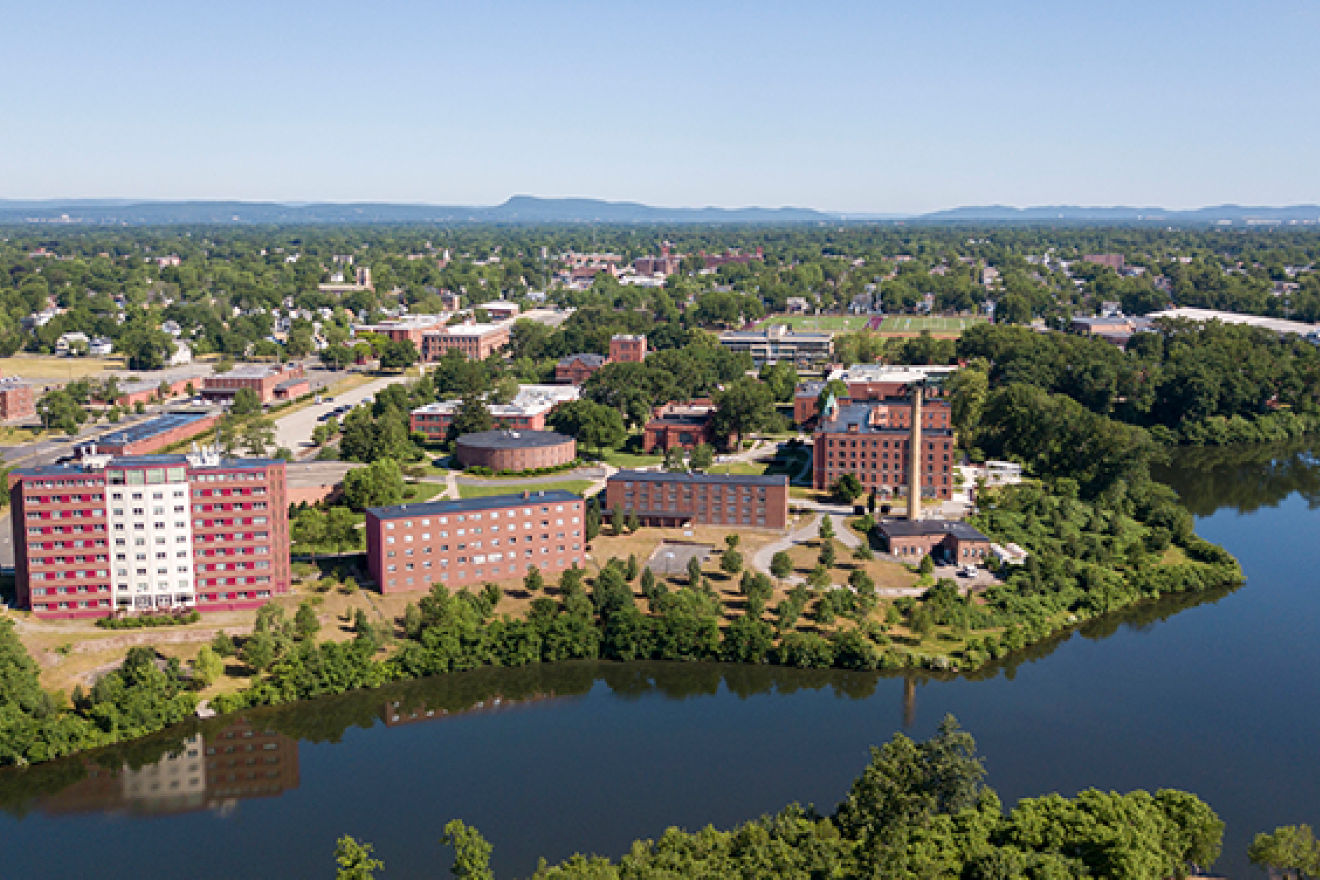 aerial shot of campus by lake 