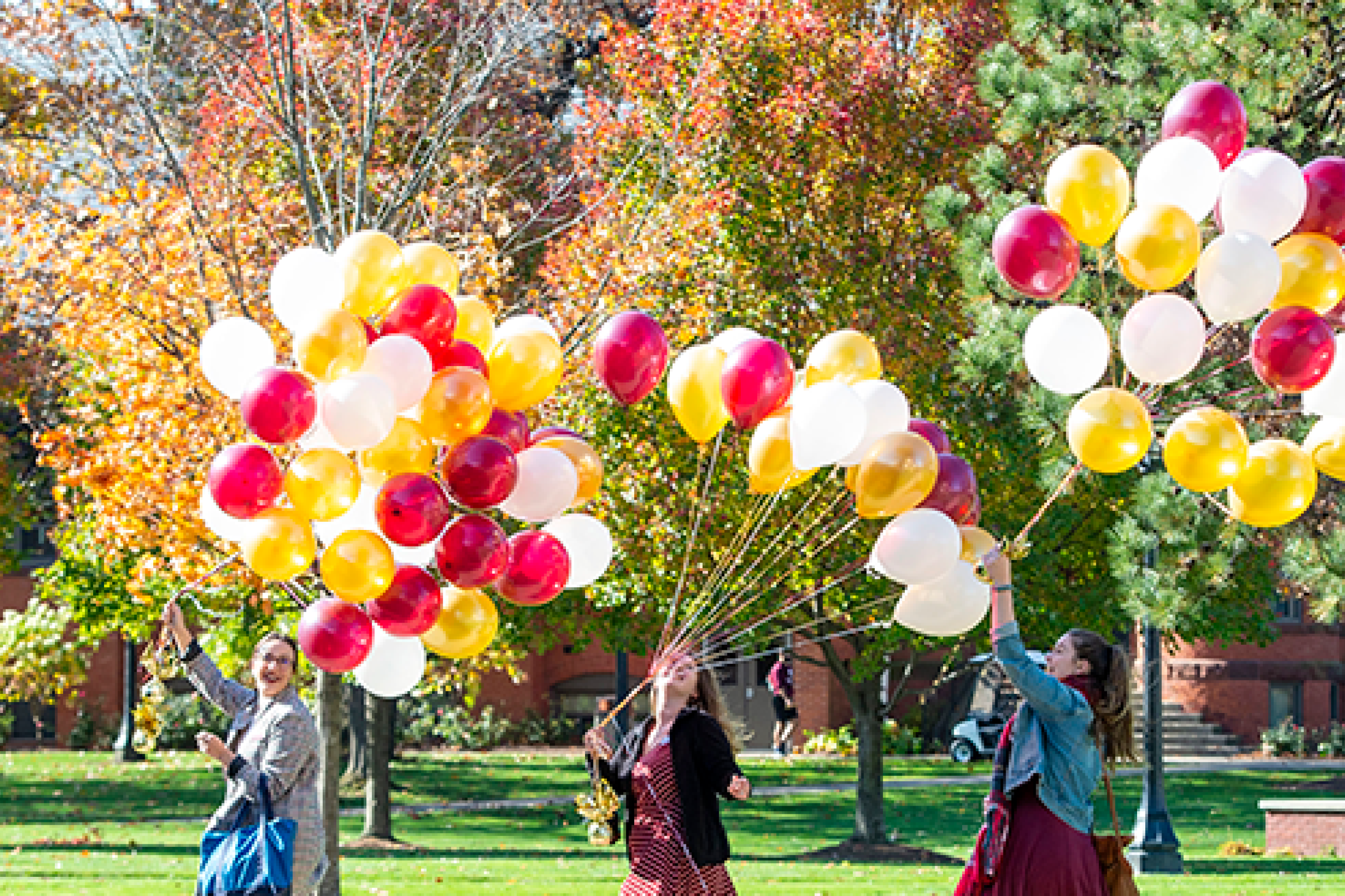 walking with balloons on campus