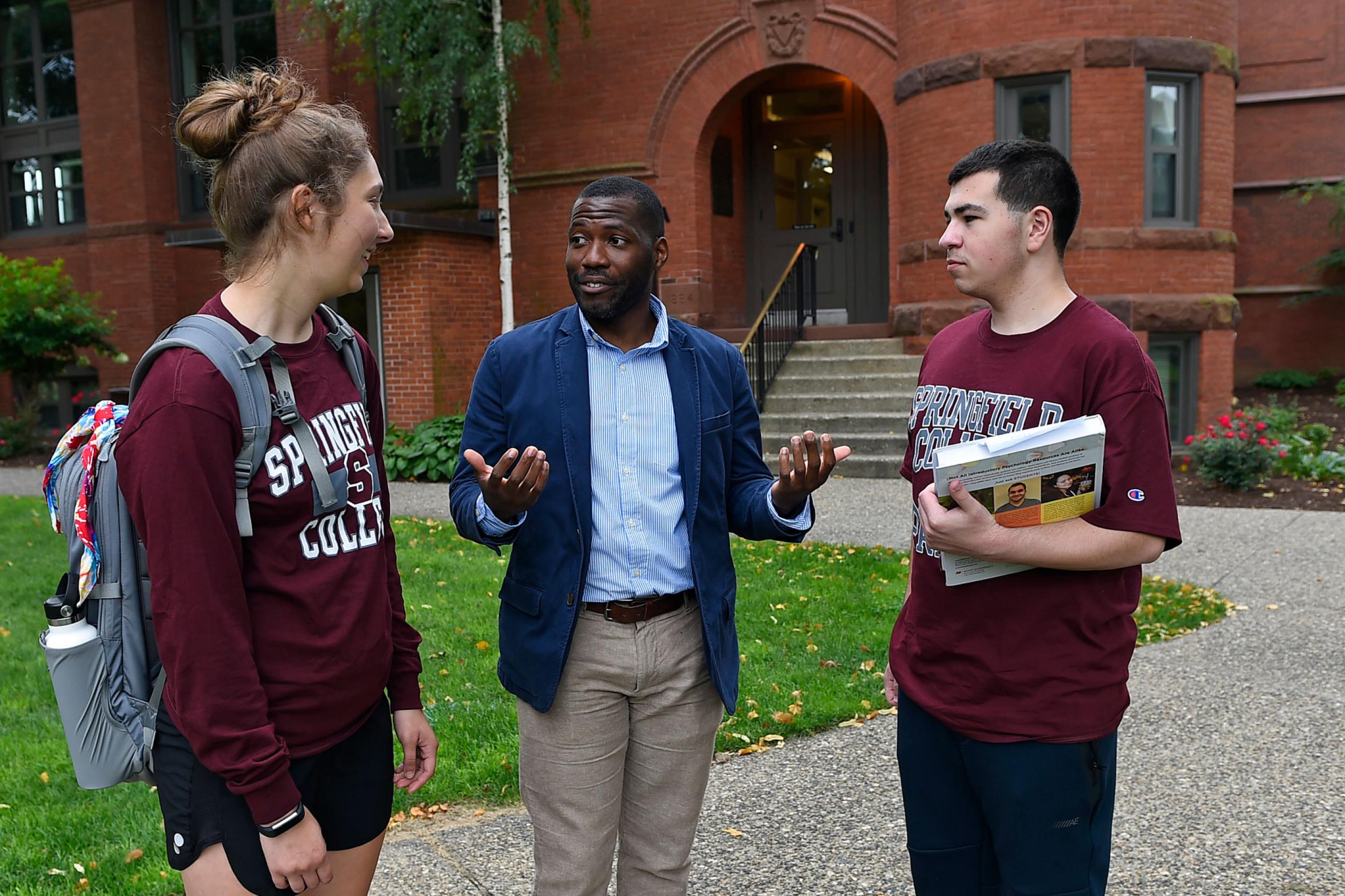 Professor Korey Boyd speaks with two Springfield College students