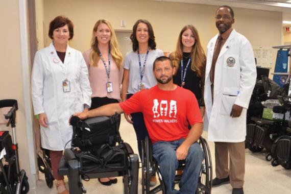 Veteran Tim Conner, seated, with his new exoskeleton and the team that helped make it possible