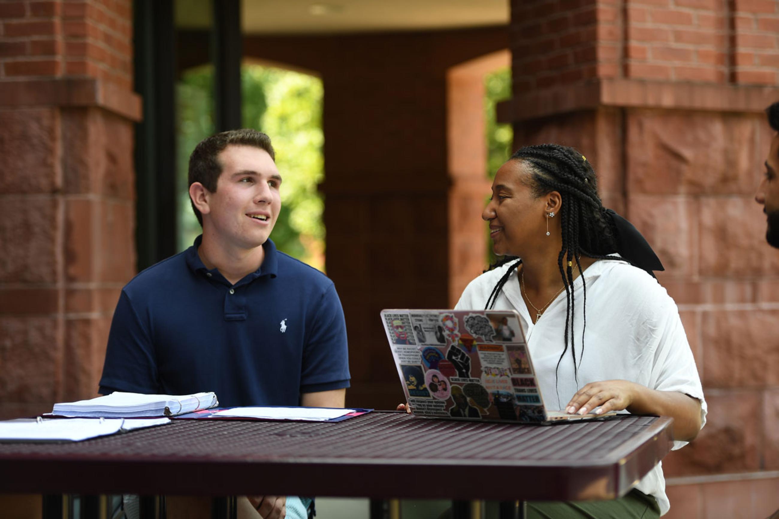 Two students sit at a table on the Springfield College Campus