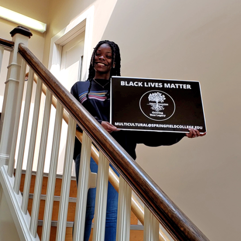 Student on stairs with BLM sign