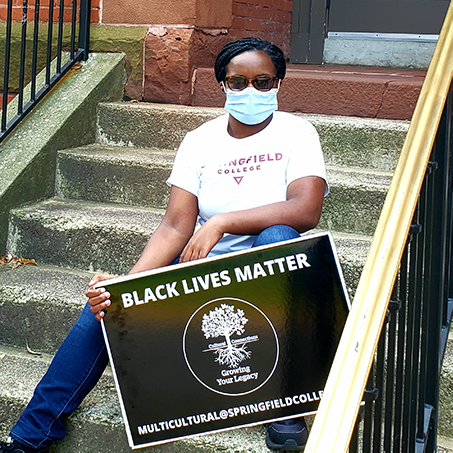 student with mask holding BLM sign