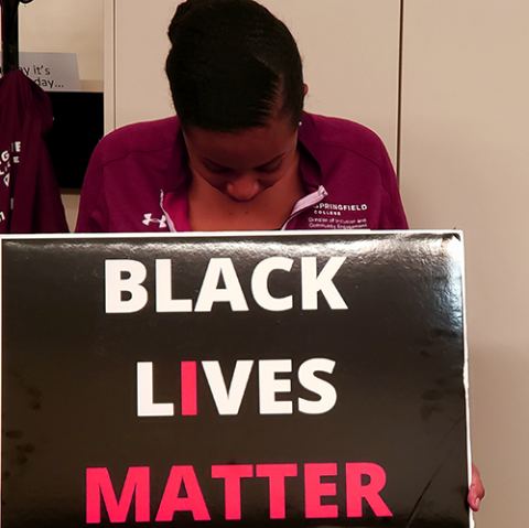 student looking at a BLM sign