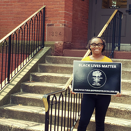 woman with eyeglasses holding Black Lives Matter sign