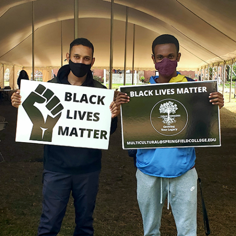 two male students with Black Lives Matter signs