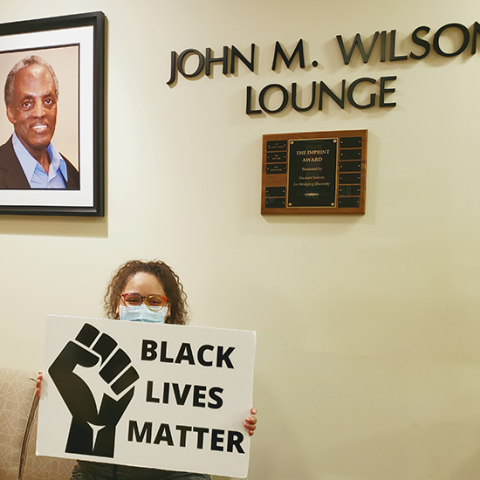 student holding BLM sign in John M. Wilson lounge