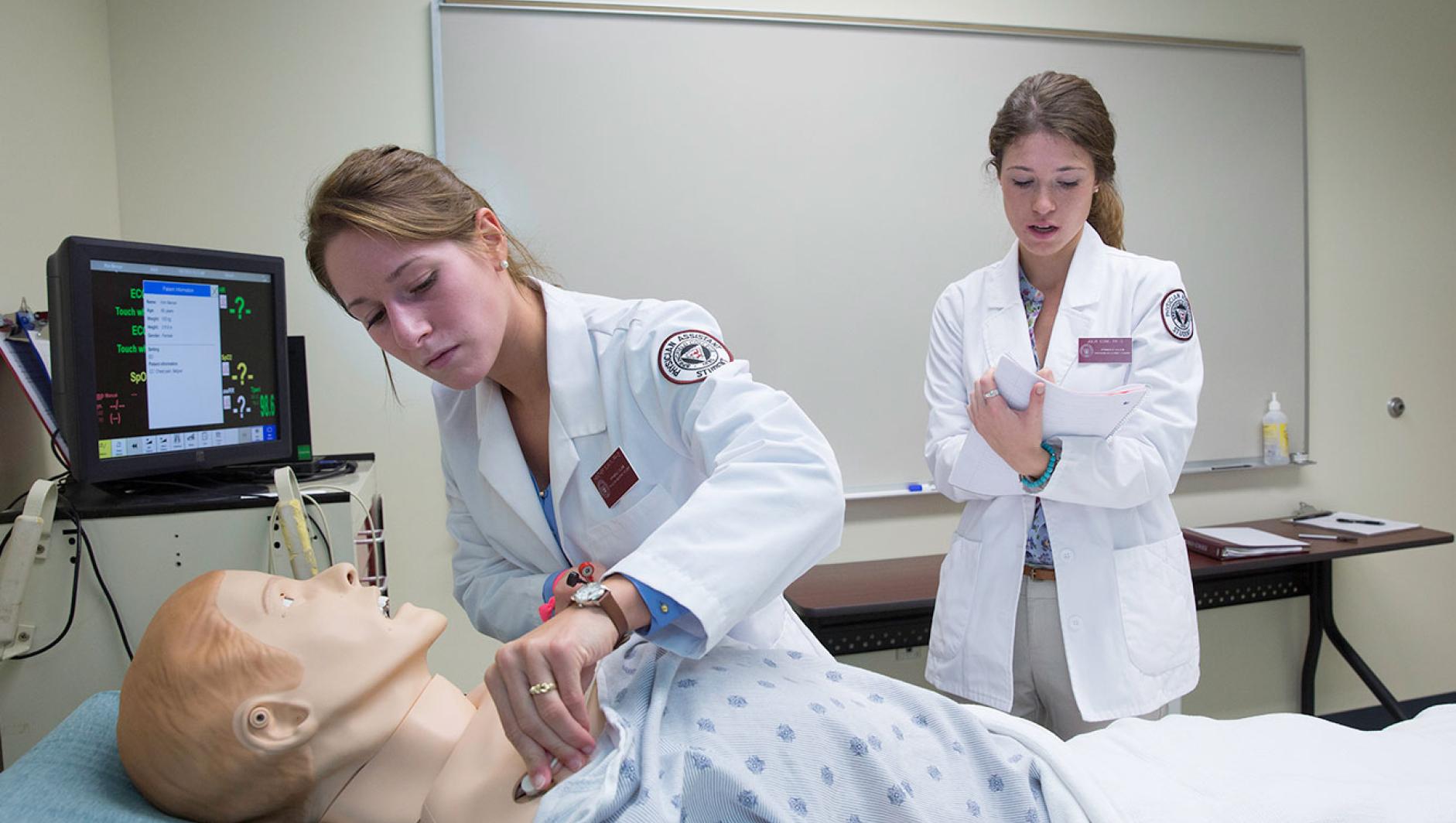 Sim lab students with simulation mannequin