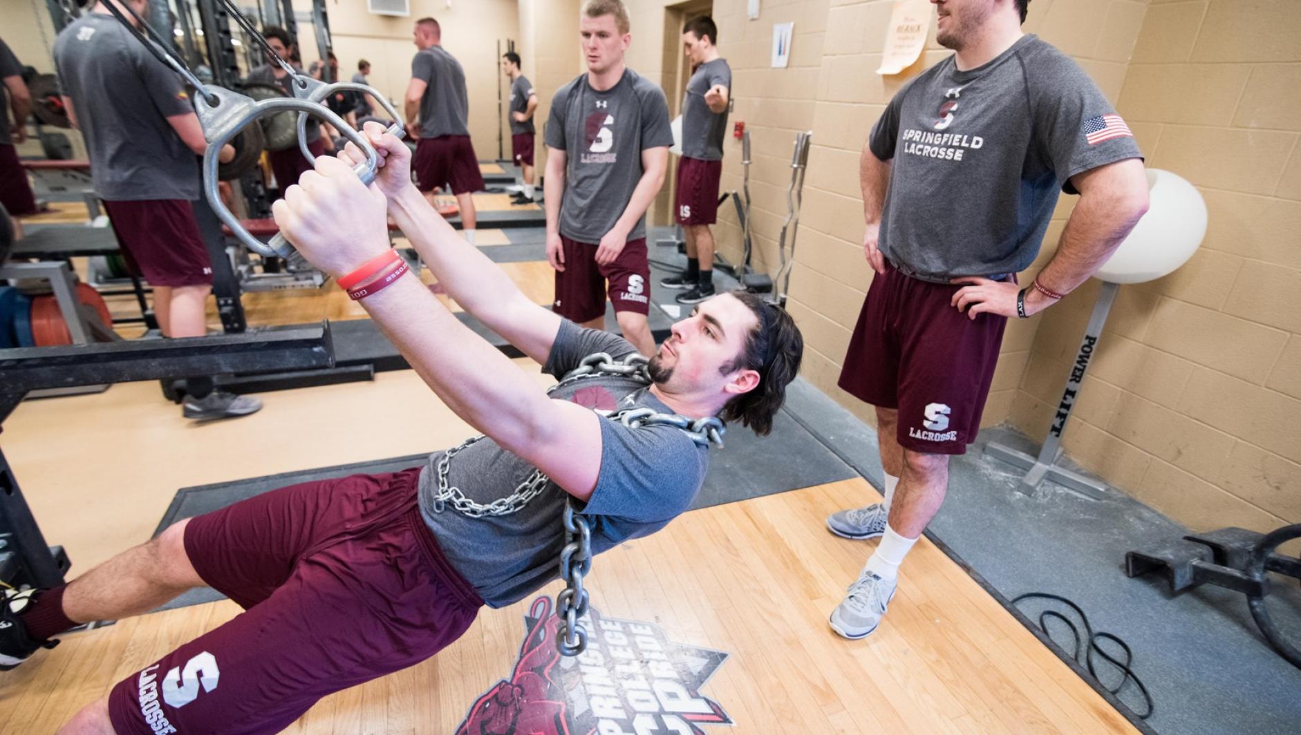 A student works out his upper body utilizing equipment in the strength and conditioning facility.