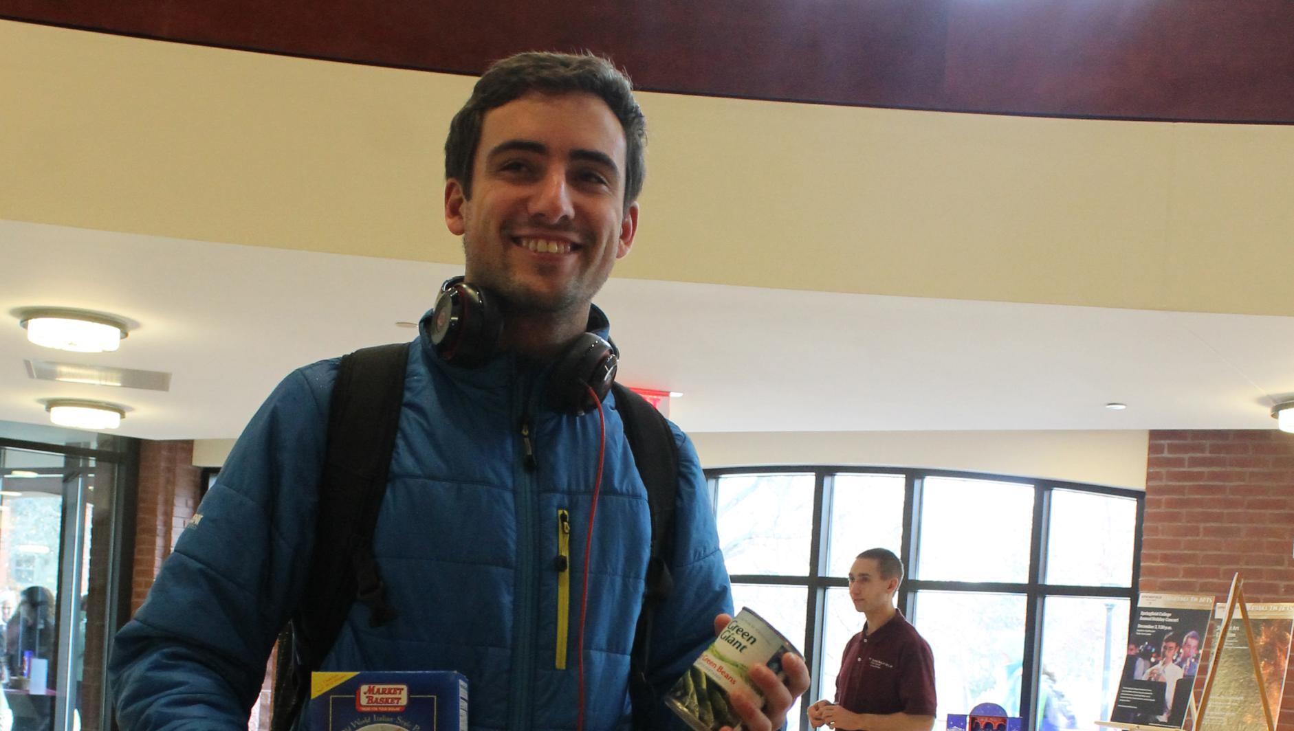Student donating canned items at #GivingTuesday
