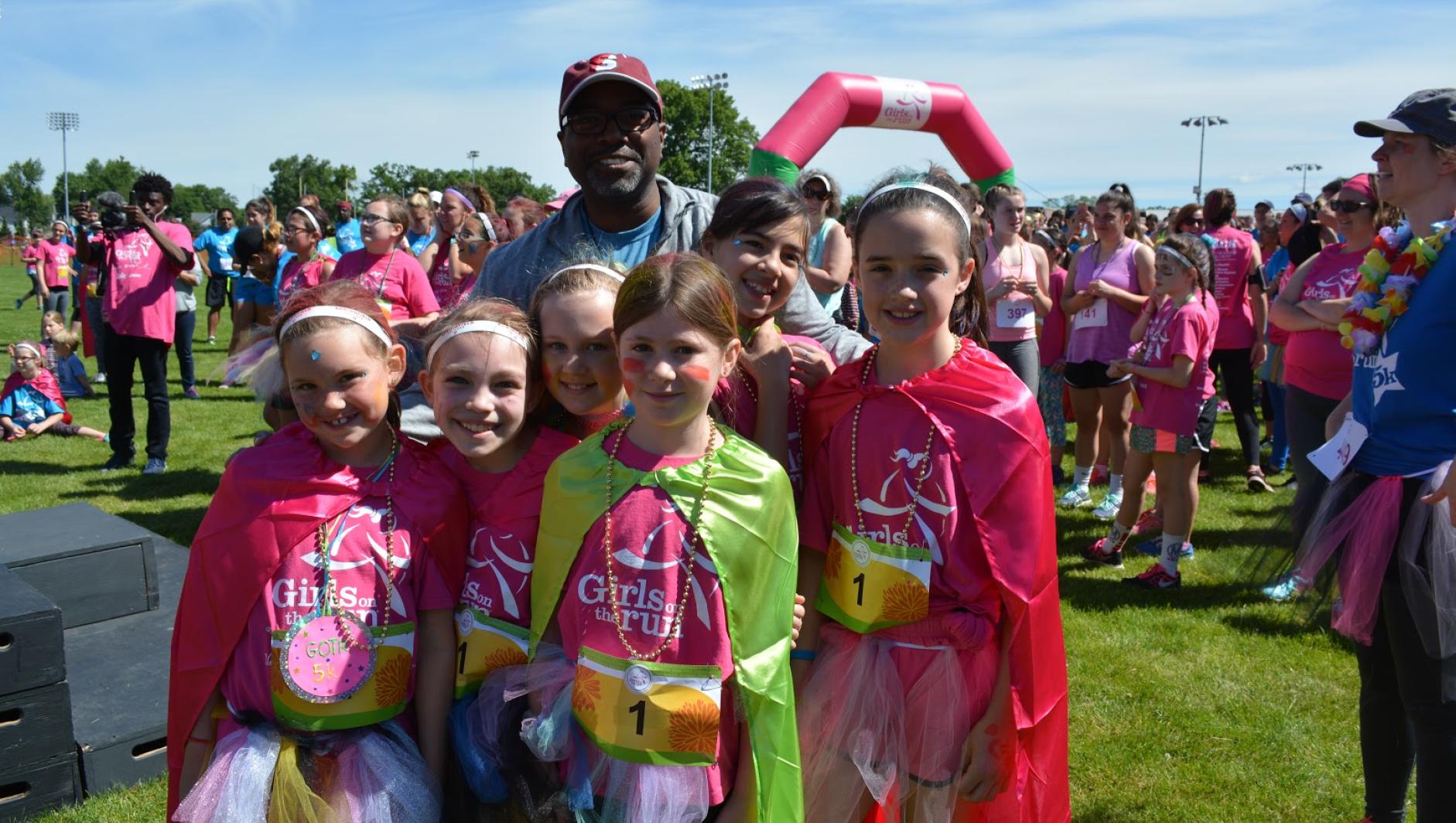 Calvin Hill poses with Girls on the Run participants. 