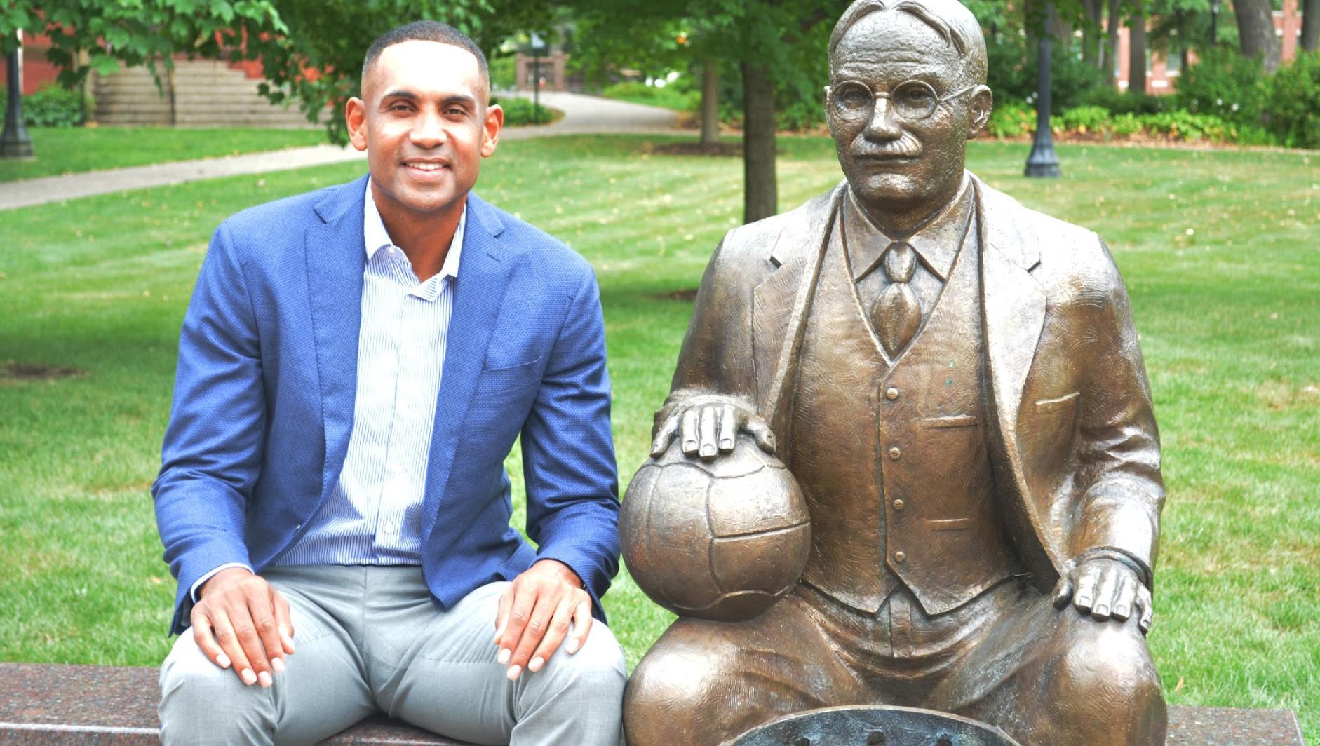 Grant Hill sitting next to the Naismith Statue