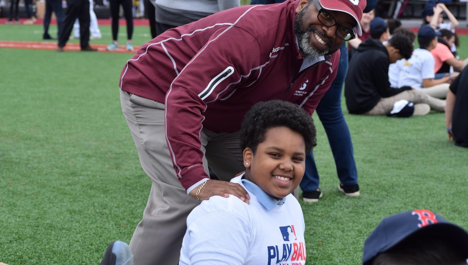 Calvin Hill poses with a participant during Play Ball event. 