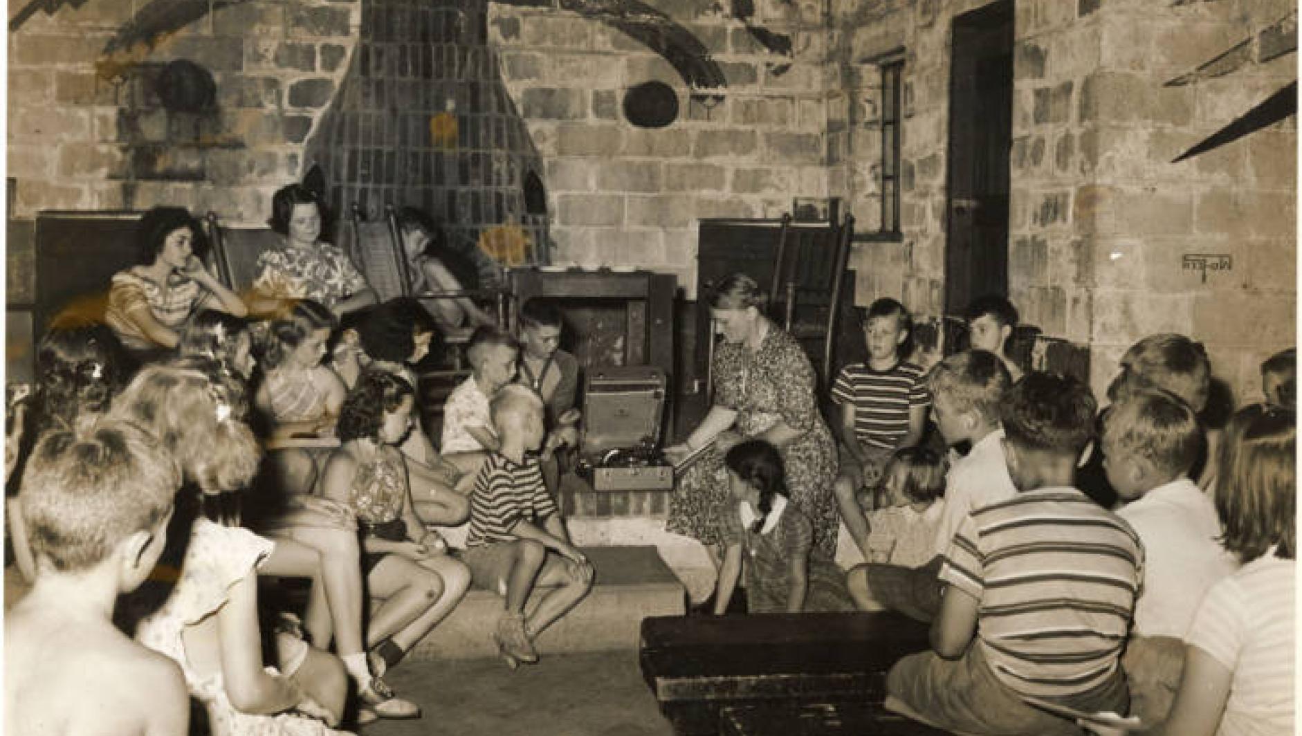 Students sit in a building at Camp Massasoit and listen to music. 
