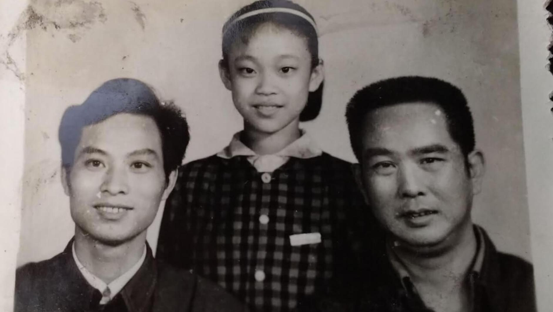 Li Jin as a child stand between her father and uncle. 