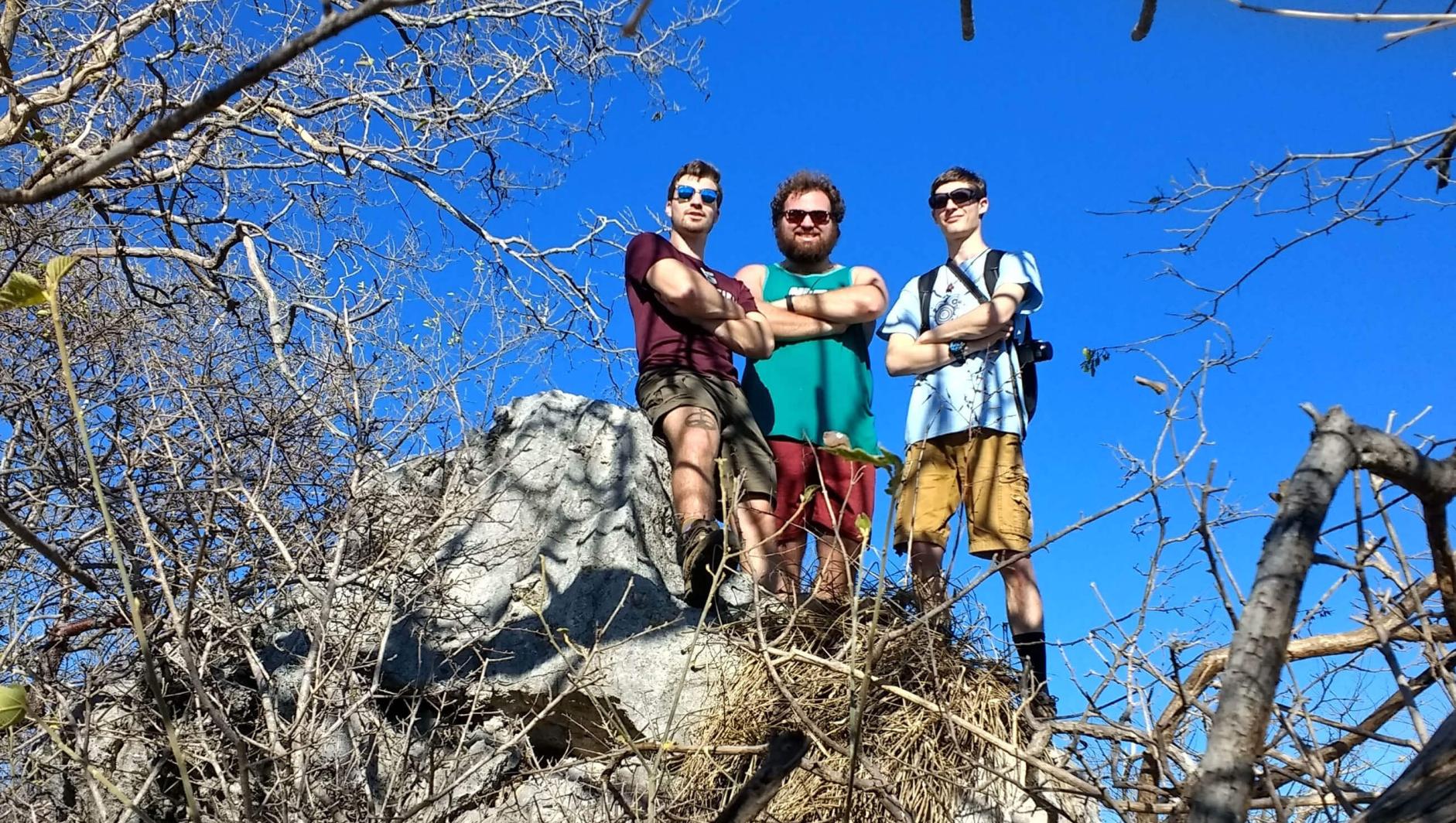 Students stand on top of a rock during a hike. 