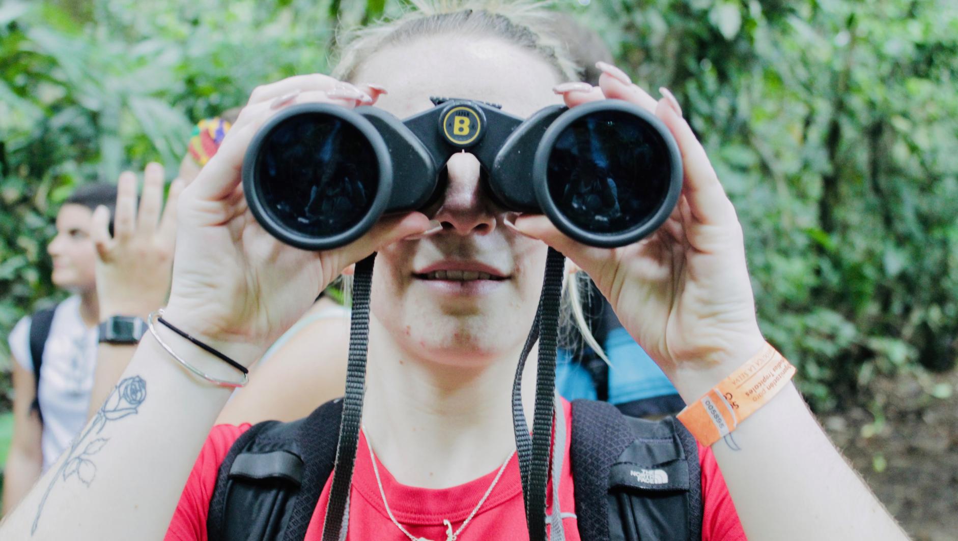 Girl looks through binoculars in Costa Rica