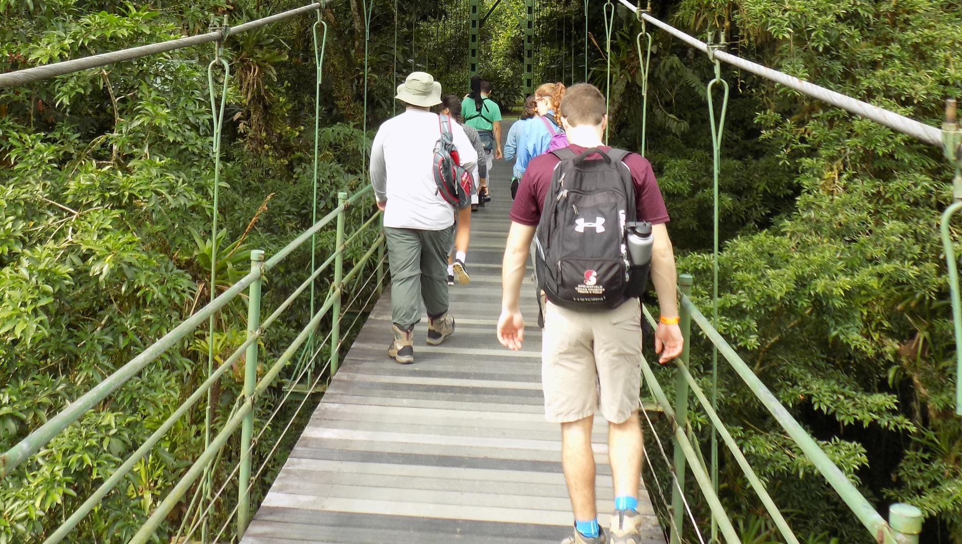 students walk across a rope bridge in Costa Rica