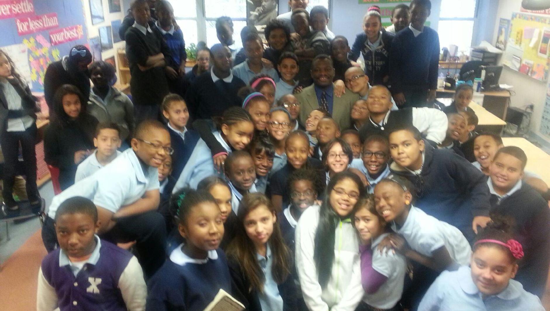 Dr. Hill visits MLK Charter school and poses with children. 