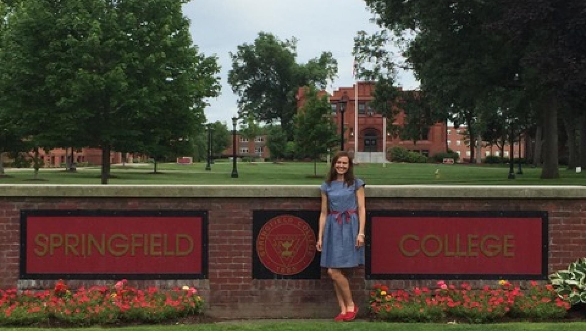 Watkins in front of the Springfield College sign. 