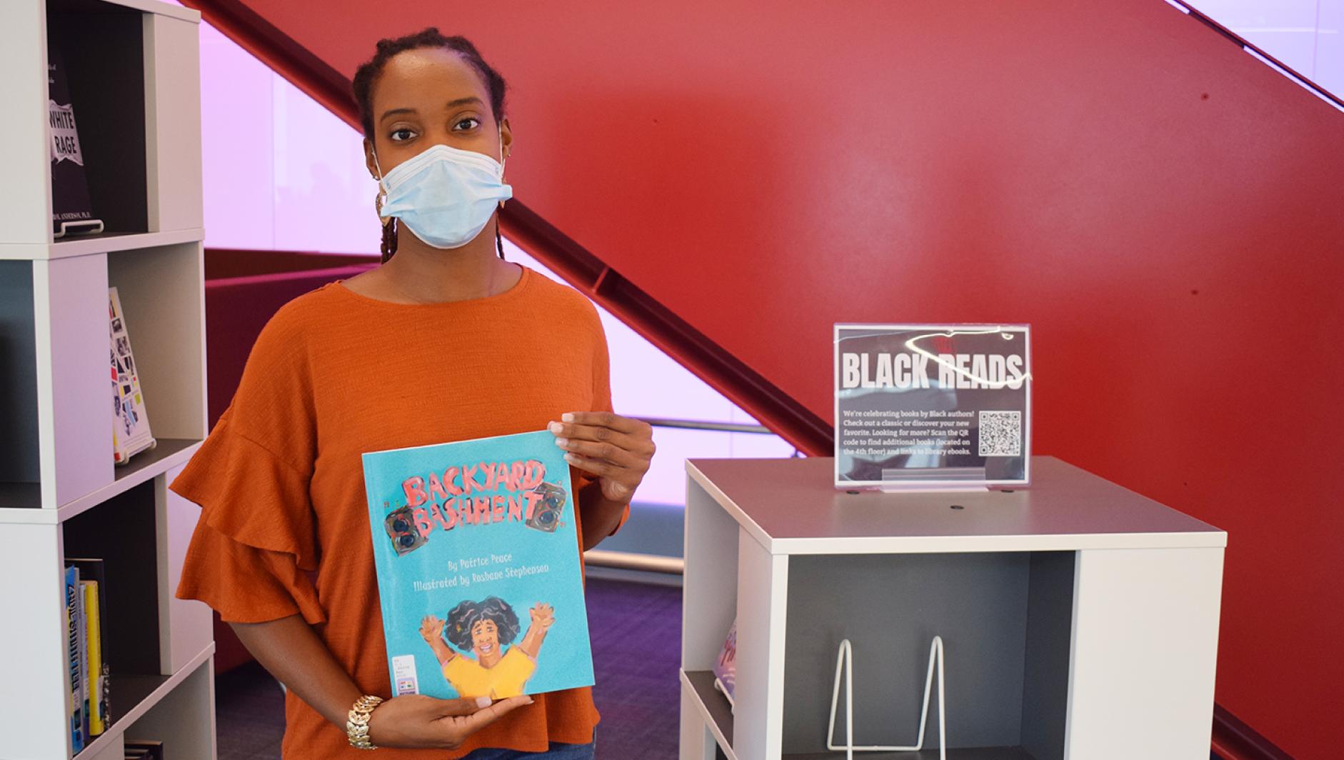 Photo of Sheona Douglas holding a copy of her book