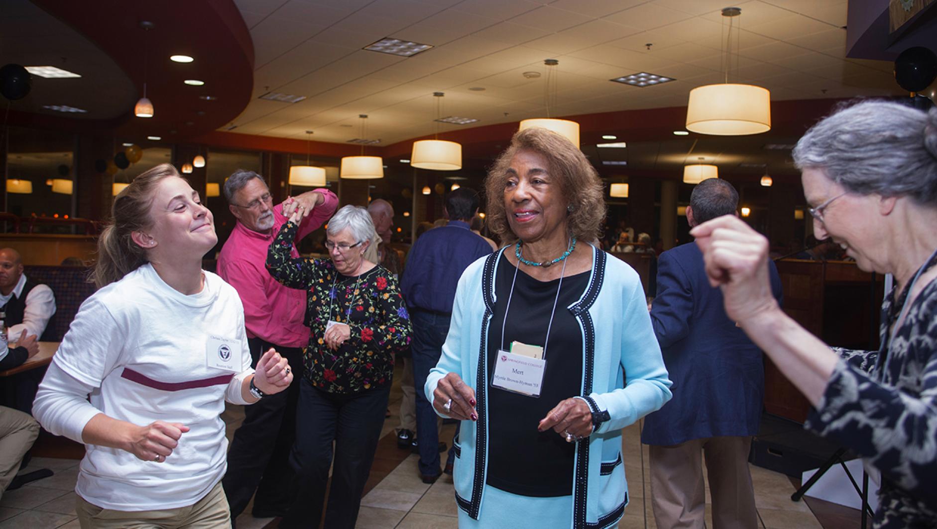 a student volunteer dancing with Reunion attendees