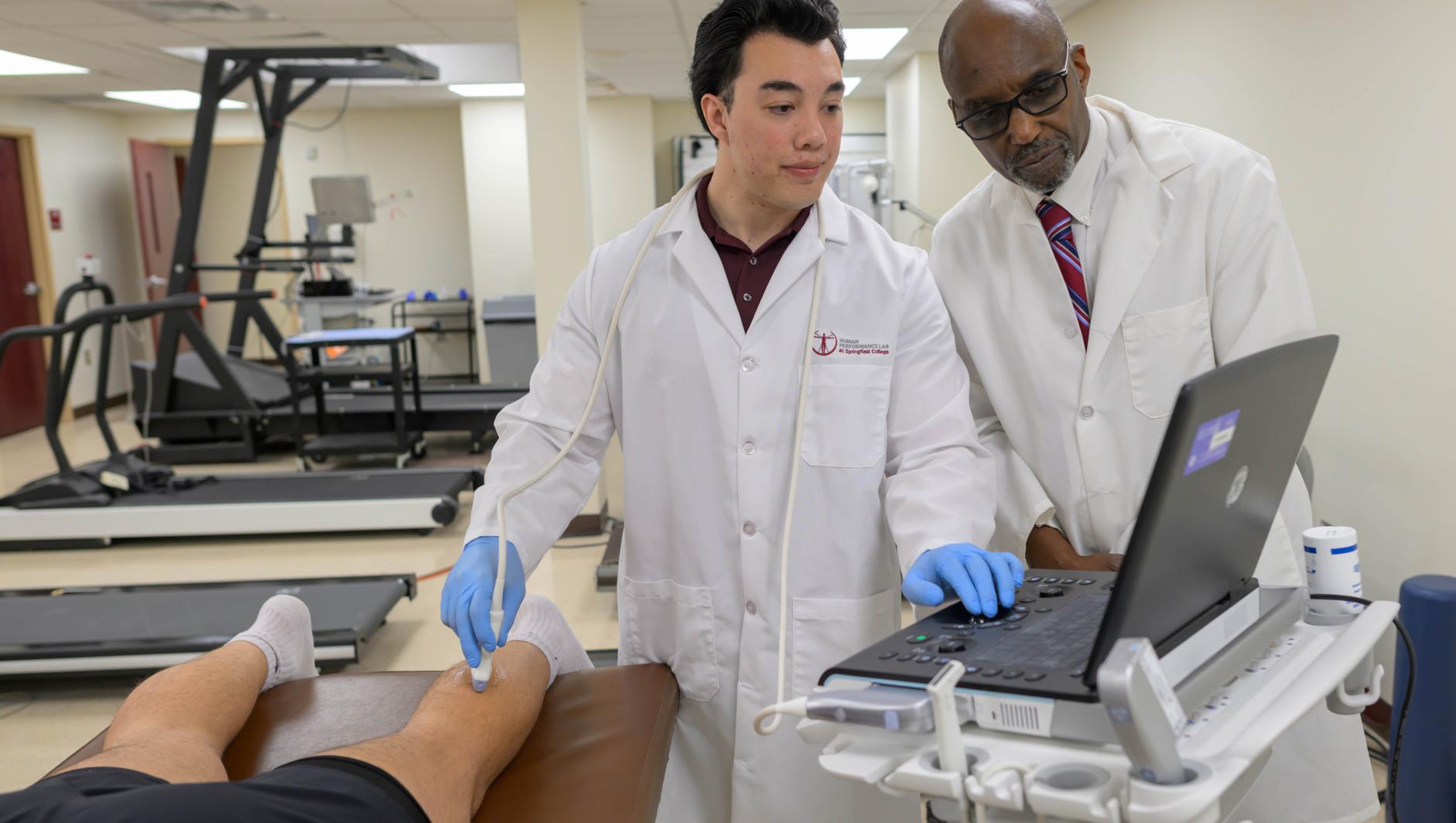 Springfield College exercise physiology graduate student Christopher Mette, left, and Professor of Exercise Science Samuel A.E. Headley work with diagnostic ultrasound machine