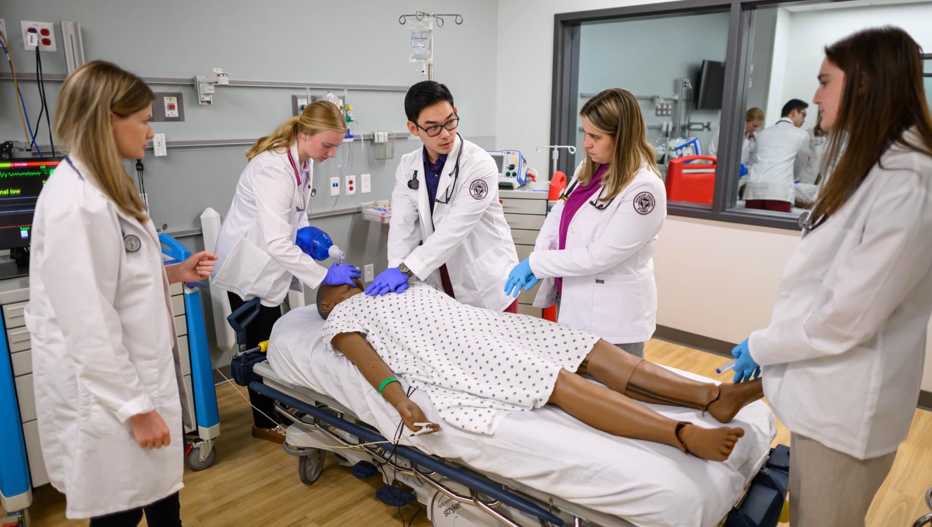 Springfield College Physician Assistant students work with realistic simulation mannequins inside the Robotti Simulation Center at the Health Sciences Center