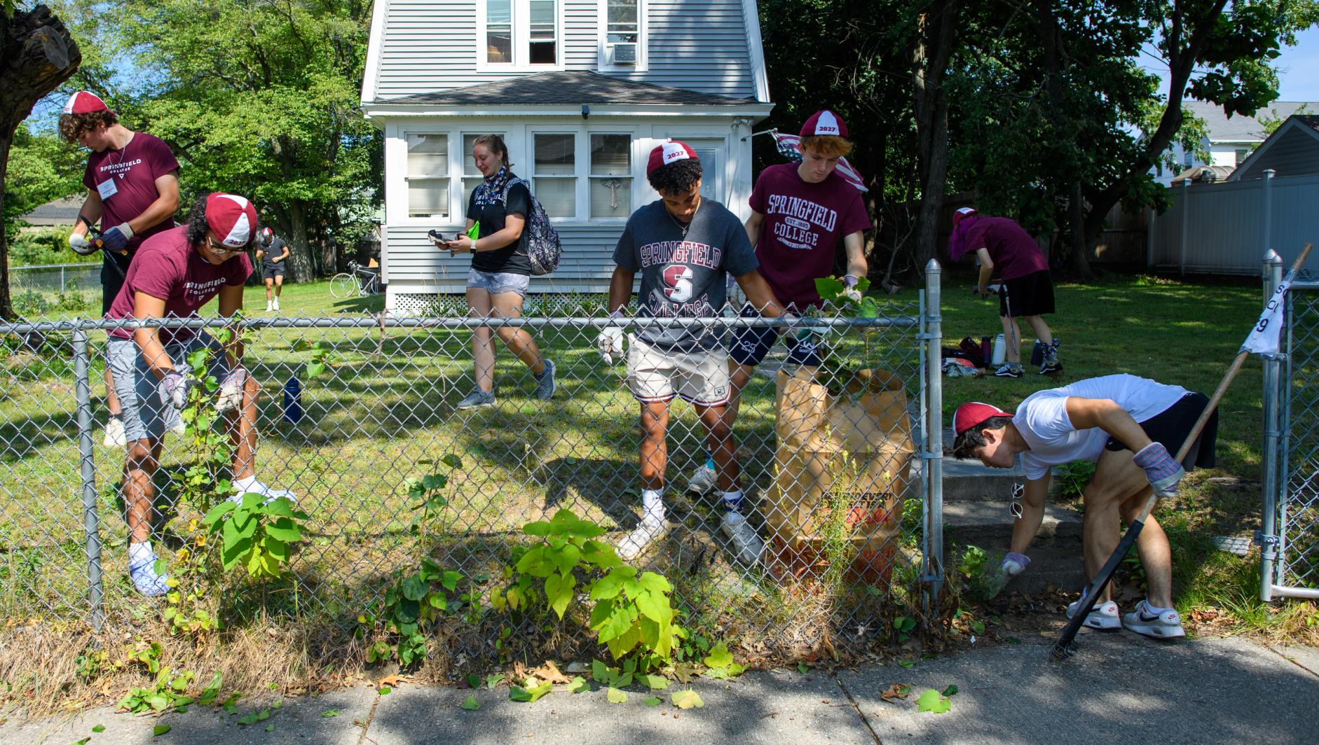 Students cleaning up a yard in Springfield neighborhood