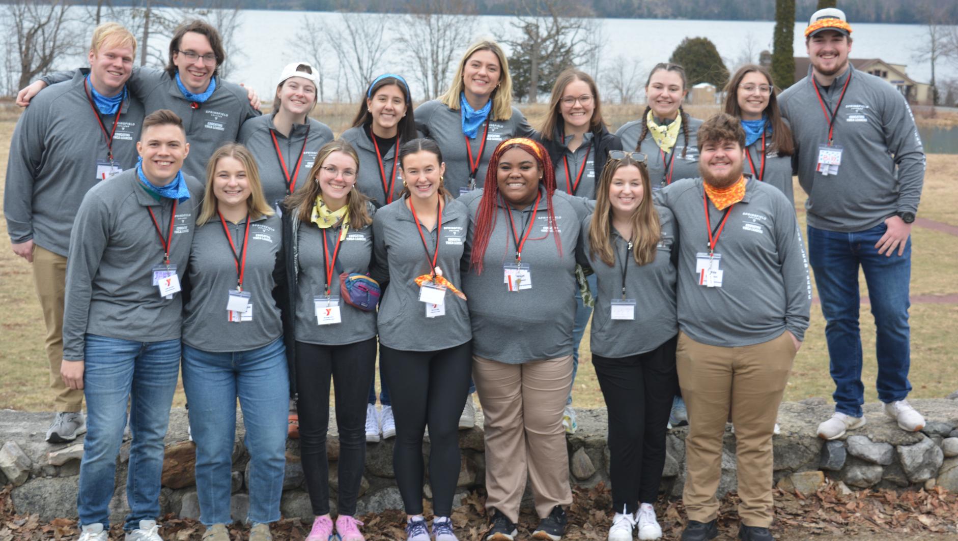 Group of all students standing in front of water at annual leadership summit.