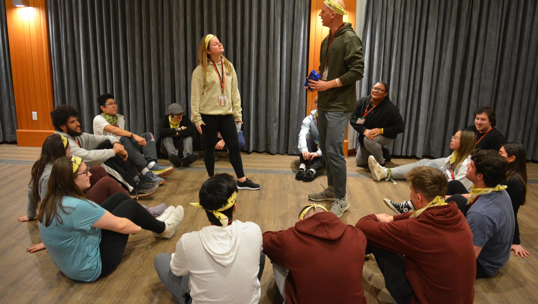 Group of students sitting in a circle on the floor at the annual leadership summit