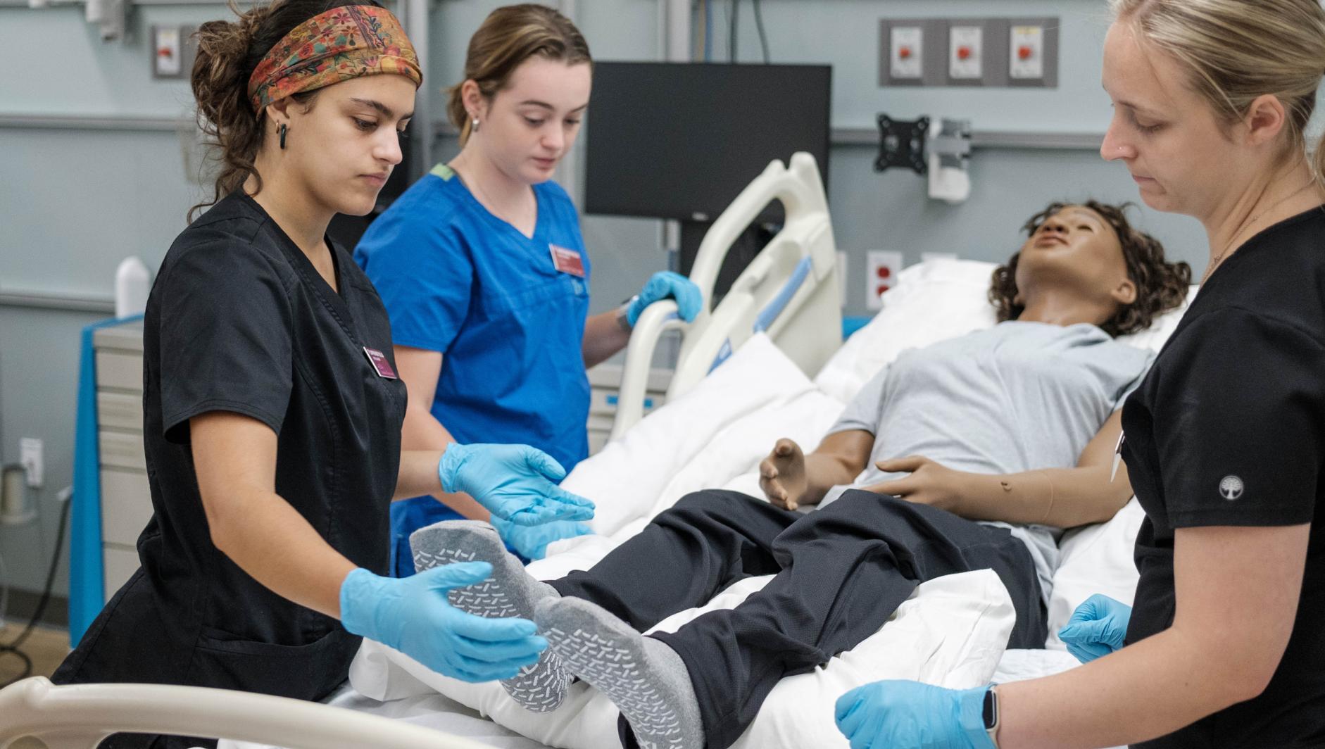 Springfield College Occupational Therapy students work with realistic simulation manikins to develop bed level care skills for dependent clients inside the Robotti Simulation Center at the Health Sciences Center on July 1, 2024.