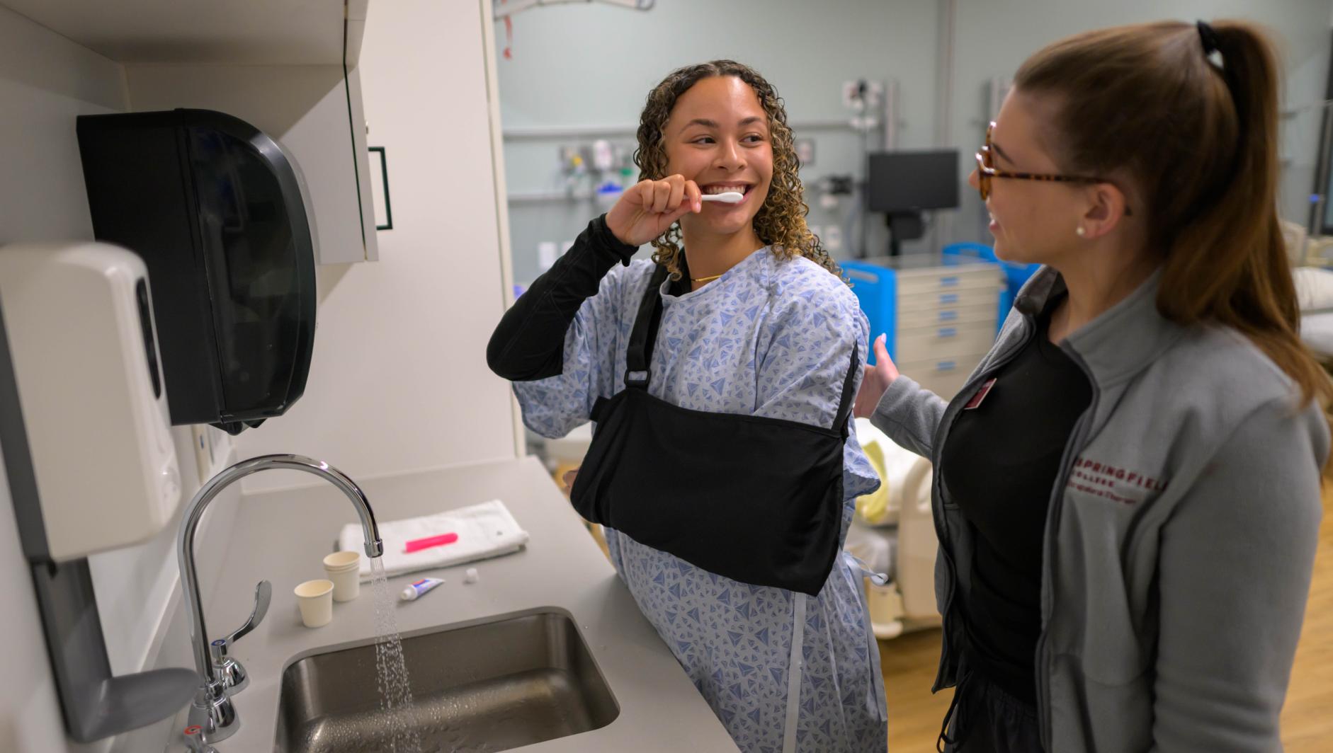 Springfield College Occupational Therapy students are encouraged to step outside their comfort zone as they are randomly paired with members of their cohort to practice providing clients with assistance to manage self care including bathing, dressing, toileting and grooming inside the Robotti Simulation Center on June 21, 2024.