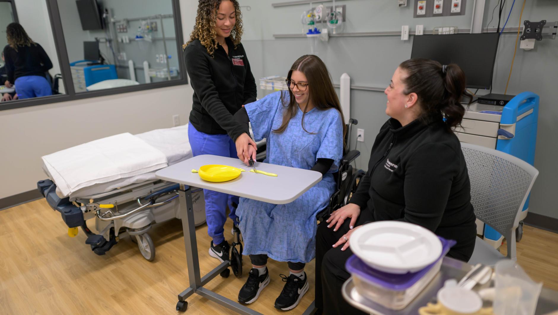 Springfield College occupation therapy students and Assistant Professor of Occupational Therapy Elizabeth Alicea-Torres train inside the simulation lab at the Health Sciences Center on April 23, 2024.