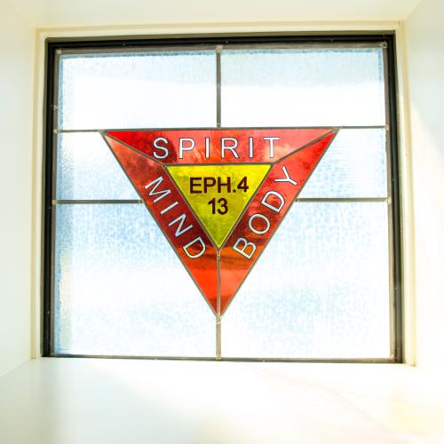 A window in Judd Gymnasia that reads "spirit, mind, and body"